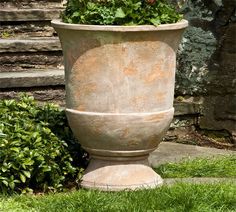 a large potted planter sitting on top of a grass covered ground next to steps