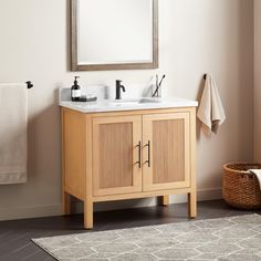 a bathroom vanity with two sinks and a mirror above it, in front of a beige wall