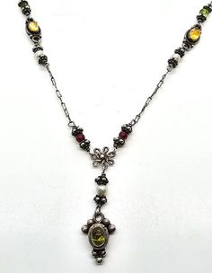 Boho multi Gemstone Garnet citrine peridot tribal sterling silver vintage necklace. Good used condition with little to no signs of normal wear. Great patina present. Stamped 925 on the back of the pendant and the clasp. Unique decorated S clasp has a citrine cab in the center. Each bead is faceted gemstone which include: peridot, citrine, garnet and white pearl. Acid tests positive for sterling silver. Gemstones tested with Presidium II gemstone tester. Necklace measures 18 inches long. Pendant measures a 1 and 1/2 inch drop and 3/8ths of an inch wide. Antique Multi-stone Pendant Necklace, Silver Long Necklace With Stones, Antique Yellow Pendant Jewelry, Bohemian Sterling Silver Stone Necklaces, Antique Silver Jewelry With Natural Stones, Bohemian Multi-stone Pendant Jewelry, Antique Amber Necklace With Gemstone, Antique Amber Gemstone Necklace, Vintage Amber Sterling Silver Necklace