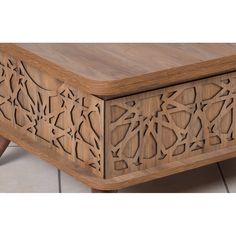 a wooden box with carvings on it sitting on the floor next to a planter