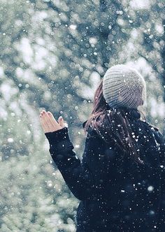 a woman standing in the snow with her hand up to her face, saying too cold to be sent