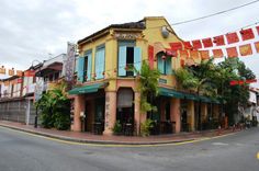 a street corner with an orange building and flags on the side of it, along with palm trees