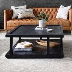 a brown leather couch sitting next to a coffee table