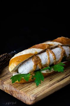 a sandwich with meat and vegetables on a cutting board