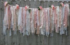 pink and white lace garland hanging from a fence