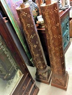 three tall wooden vases sitting next to each other in front of a mirror on the floor