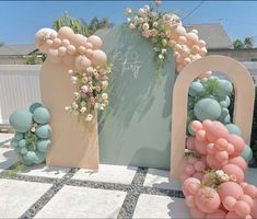 an arch decorated with balloons and flowers