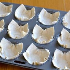 a muffin tin filled with cupcake batters on top of a wooden table