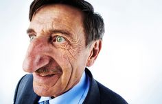 an older man wearing a suit and tie with his eyes wide open, looking at the camera