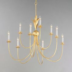 a gold chandelier with many candles hanging from it's arms and bottom