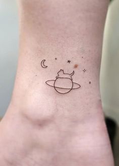 a small saturn tattoo on the ankle