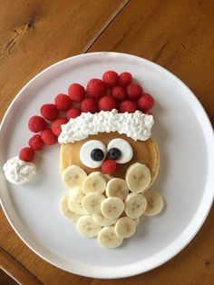 a white plate topped with fruit and a face made to look like a man's face