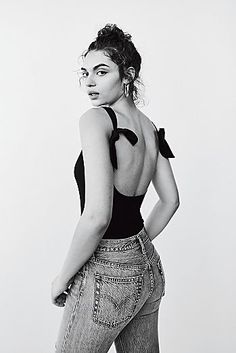 a black and white photo of a woman with her back to the camera, wearing high waist jeans