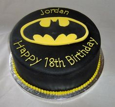 a batman themed birthday cake with the name happy 18th birthday written in yellow on it