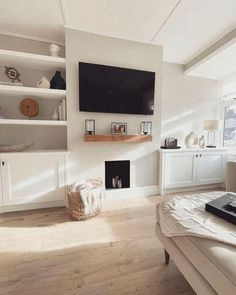 a living room filled with furniture and a flat screen tv mounted on the wall above a fireplace