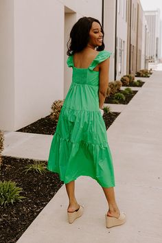 - This sweet dress is perfect for a sunny day! - Lightweight, green hued material with a lined bust - A scoop neckline - A bust with gathered detail - Flutter sleeves with elastic shoulders - A smocked upper back - A relaxed silhouette that ends in a straight midi length hemline Green Flutter Sleeve Summer Dress, Green Flutter Sleeve Dress For Vacation, Green Ruched Midi Dress With Square Neck, Green Ruffled Straps Vacation Dress, Green Vacation Dress With Ruffled Straps, Green Flutter Sleeve Beach Midi Dress, Green Ruched Midi Dress For Beach, Green Midi Dress With Flutter Sleeves, Green Spring Dresses With Ruffled Straps