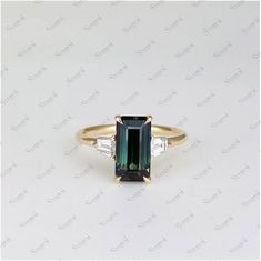 A teal sapphire emerald cut, framed by a pair of white diamond tapered baguettes. Set in 18ct yellow gold in a signature SugoiStore band.  Centre stone: 2.66ct Teal sapphire Approx. shoulder stone weight: 2=0.46ct F-VVS clarity. ► PROCESSING & SHIPPING Processing time: 1-2 weeks after placing order, International Buyers Please Note: In some cases, additional custom fees and duties may be charged, depending on the country the items are shipped to. Buyers are responsible for any customs and import Ring Saphir, Peacock Sapphire, Emerald Cut Sapphire Ring, Teal Sapphire Ring, Parti Sapphire, Ring Emerald Cut, Teal Sapphire, Ring Sapphire, Ring Emerald