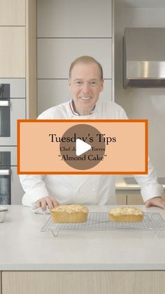 a man standing in front of a counter with two muffins on top of it