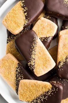 chocolate dipped shortbreads on a white plate with sprinkles and sea salt