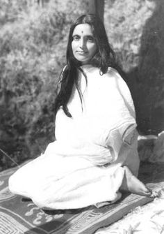 an old photo of a woman sitting on the ground