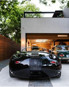 a black sports car parked in front of a garage