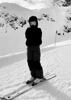 a person standing on skis in the snow with mountains in the backgroud