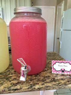 a pink drink in a mason jar on a kitchen counter next to a soap dispenser