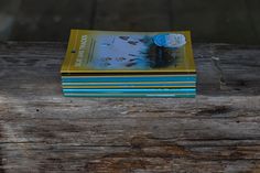 a stack of books sitting on top of a wooden table