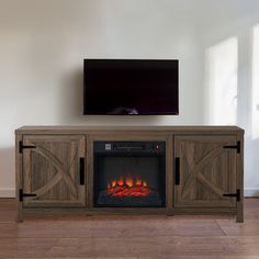 an entertainment center with a fireplace and flat screen tv