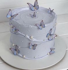 a white cake with blue butterflies on it