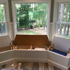 the inside of a room with three windows and two benches in front of large windows