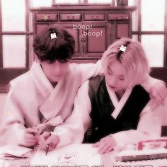 two people sitting at a table writing on paper with the words good luck written below them