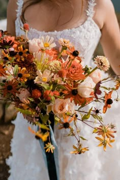 a woman holding a bouquet of flowers in her hands