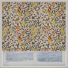 an orange and lemon patterned roman blind in front of a window