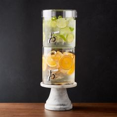 three tiered beverage dispenser filled with lemons and grapes