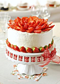 there is a cake with strawberries on the top and bottom, sitting on a table