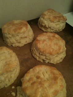 four biscuits sitting on top of a cookie sheet