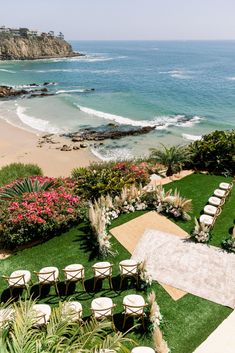 an aerial view of a wedding ceremony setup on the lawn overlooking the beach and ocean