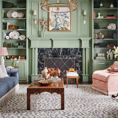 a living room filled with furniture and a fire place in front of a green wall