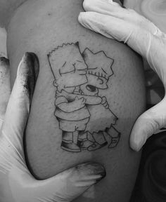 the simpsons tattoo is on someone's thigh and it looks like they are hugging