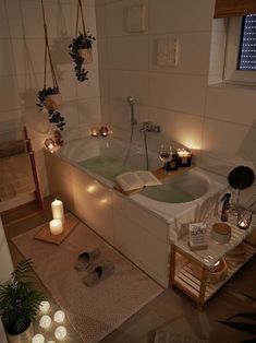 a bathtub with candles on the floor next to it