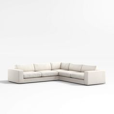 a white sectional couch sitting on top of a white floor