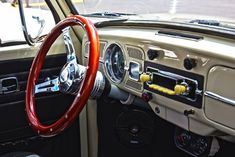 the interior of an old car with wood steering wheel