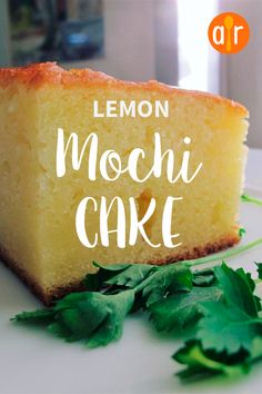 lemon mochi cake on a white plate with fresh parsley sprinkled around it