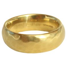 a gold wedding ring on a white background