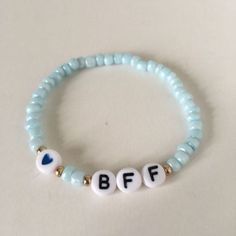 a beaded bracelet with the word bff spelled in white letters on blue beads