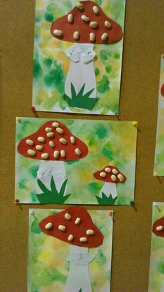 four mushroom paintings are displayed on the wall with green and yellow paint, one has white mushrooms