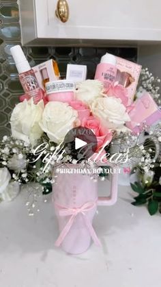 a vase filled with lots of white and pink flowers on top of a countertop