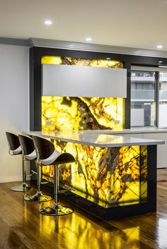 the bar is decorated with yellow leaves and black barstools in front of it