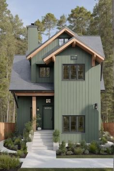 a house that is green and has some plants in front of the entrance to it